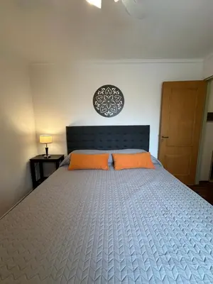 a bedroom with a large bed with two orange pillows at Departamento alquiler temporal 6 D INVERHOME INMOBILIARIA in Cordoba