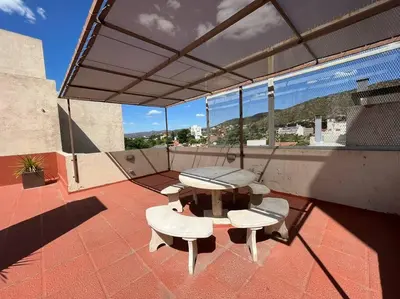 a patio with a table and chairs on a roof at Departamento 2 dormitorios excelente ubicacion in Villa Carlos Paz