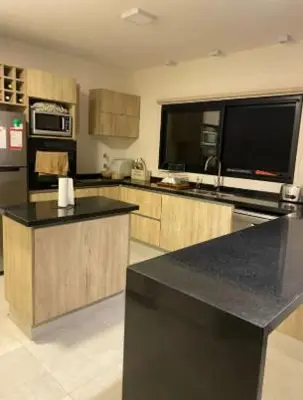a large kitchen with a black counter top at Casa en Campo de GOLF in Los Molinos