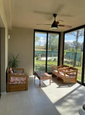 a living room with chairs and tables and windows at Casa en Campo de GOLF in Los Molinos