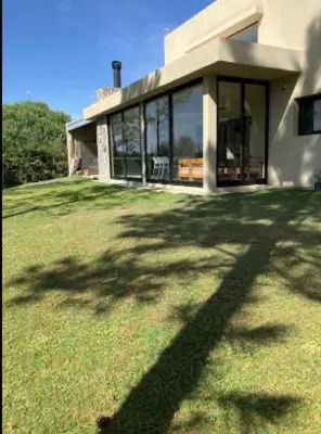 a shadow of a tree on the grass in front of a house at Casa en Campo de GOLF in Los Molinos