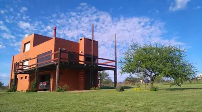 a building with a balcony on the side of it at Cabaña Espejo de Luna in La Estancia