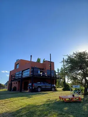a house with a car parked in front of it at Cabaña Espejo de Luna in La Estancia