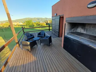 a deck with chairs and a fireplace on a building at Cabaña Espejo de Luna in La Estancia
