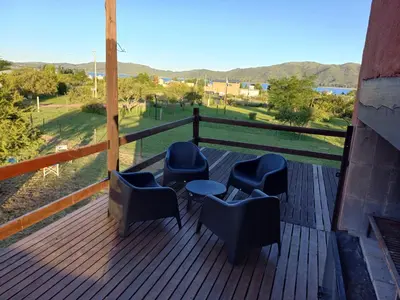 a deck with chairs and a table and a view at Cabaña Espejo de Luna in La Estancia