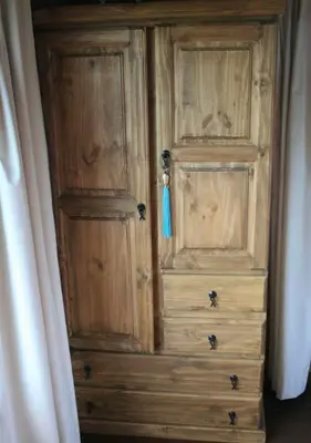 a wooden cabinet with a blue tag on it at Cabaña Espejo de Luna in La Estancia