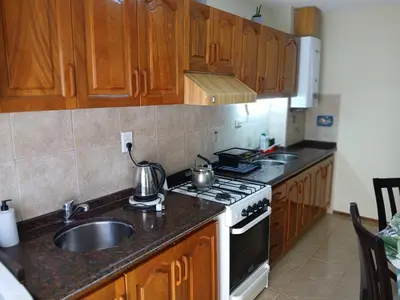 a kitchen with wooden cabinets and a stove and a sink at Adrimar Cordoba Centro in Cordoba