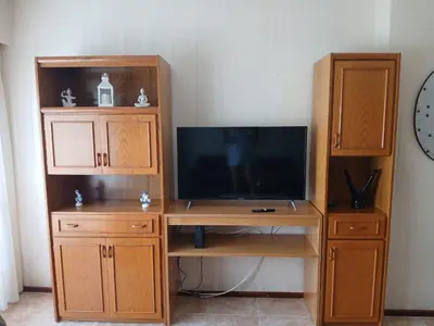 a wooden entertainment center with a tv and a desk at Adrimar Cordoba Centro in Cordoba