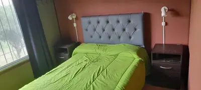 a bedroom with a bed with a green comforter at Cabaña LA LUGARDA in Cuesta Blanca