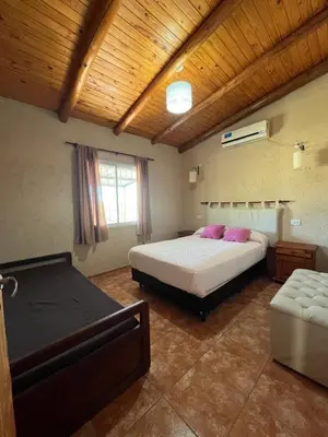 a large bedroom with a bed and a couch at Cabañas Aires de montaña in Cordoba
