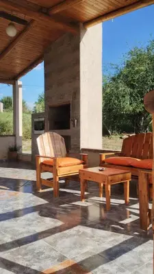 a patio with two wooden benches and a fireplace at Cabañas Aires de montaña in Cordoba