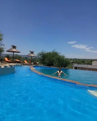 a person in the water in a swimming pool at Cabañas Aires de montaña in Cordoba