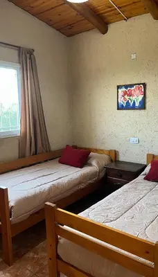 a room with two beds and a window and a window at Cabañas Aires de montaña in Cordoba