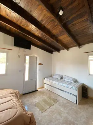 a bedroom with a large bed and a door at Cabañas Los Mellis in Barrio Parque El Corcovado