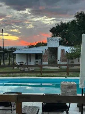 a swimming pool with a house in the background at Cabañas Los Mellis in Barrio Parque El Corcovado