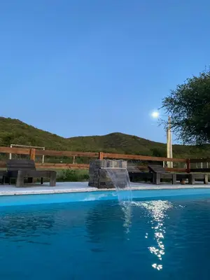 a swimming pool with a fountain and picnic tables at Cabañas Los Mellis in Barrio Parque El Corcovado