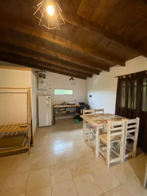 a dining room with a table and a refrigerator at Cabañas Los Mellis in Barrio Parque El Corcovado