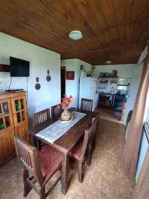 a dining room with a wooden table and chairs at Alquiler en Villa Yacanto in Villa Yacanto
