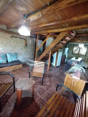 a room with benches and a table in a building at Alquiler en Villa Yacanto in Villa Yacanto