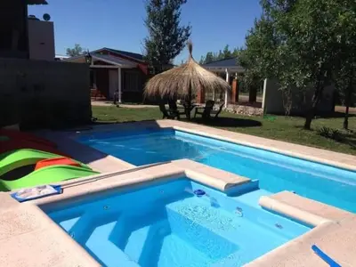a swimming pool in a yard with a house at Alquiler en Villa Yacanto in Villa Yacanto