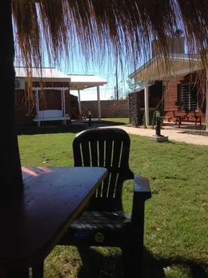 a picnic table with a bench and a hut at Alquiler en Villa Yacanto in Villa Yacanto
