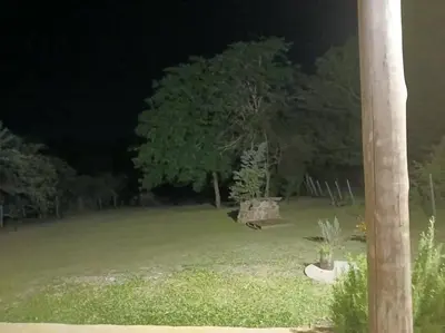 a park at night with a bench in a field at Hermosa casa para parejas in Los Reartes