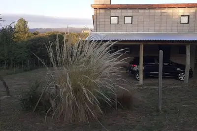 a car parked in a garage next to a house at Hermosa casa para parejas in Los Reartes