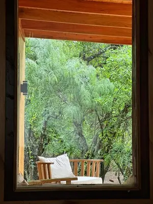 a window with a chair sitting on a porch at Ser Monte Hospedaje in La Población