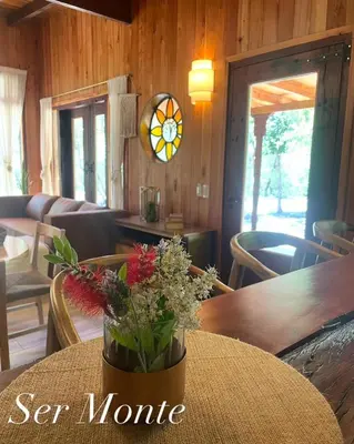 a vase of flowers sitting on a table in a room at Ser Monte Hospedaje in La Población