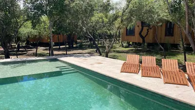 a swimming pool with two chairs and a house at Ser Monte Hospedaje in La Población