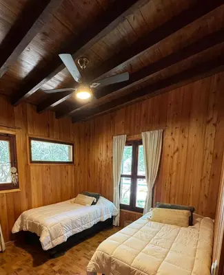 a bedroom with two beds and a ceiling fan at Ser Monte Hospedaje in La Población