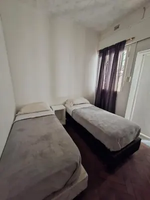two beds in a small room with a window at WHY NOT NUEVA CORDOBA in Cordoba