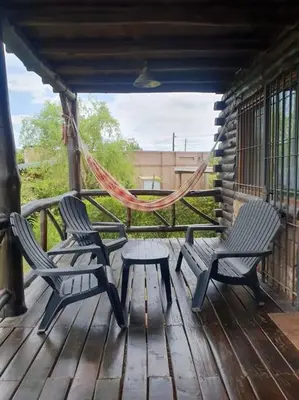 two chairs and a hammock on a wooden porch at La Traviata in Mina Clavero