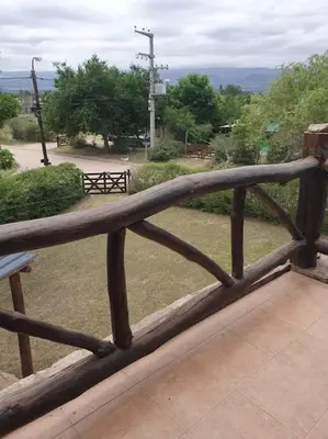 a wooden railing on a balcony with a view of a park at La Traviata in Mina Clavero