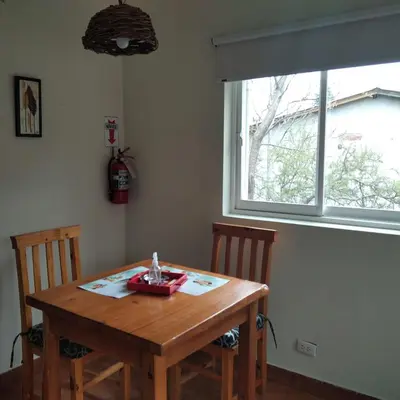 a dining room table with two chairs and a window at Viejo Camino Real in Santa Rosa de Calamuchita