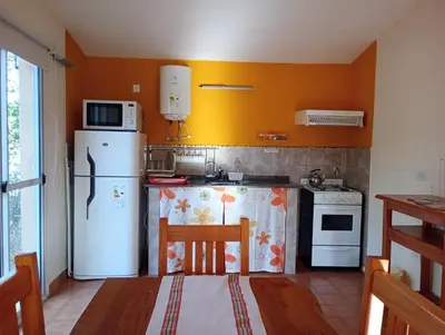 a kitchen with a white refrigerator and a stove at Viejo Camino Real in Santa Rosa de Calamuchita
