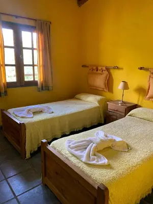 a bedroom with two beds with towels on them at Complejo de cabañas en Nono in Nono