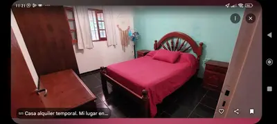 a bedroom with a bed with a red sheets and a window at Tu lugar in San Antonio de Arredondo