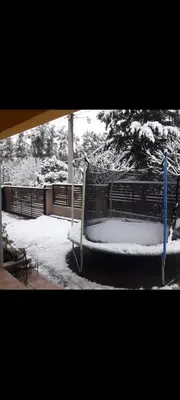 a bench covered in snow next to a fence at Tu lugar in San Antonio de Arredondo
