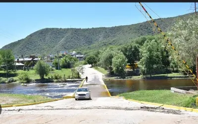 a car parked on a road next to a river at Tu lugar in San Antonio de Arredondo