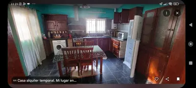 a kitchen with a table and chairs and a refrigerator at Tu lugar in San Antonio de Arredondo
