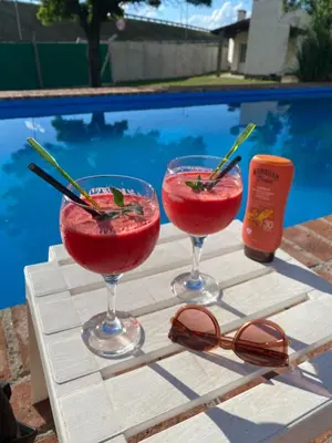 two cocktails sitting on a table next to a swimming pool at San Roque in San Roque
