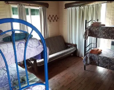 a room with two bunk beds and a couch at Estacion Potrero cabaña grande in Potrero de Garay
