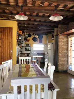 a kitchen with a table with chairs and a kitchen with at Estacion Potrero cabaña grande in Potrero de Garay