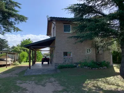 a brick house with a garage and a driveway at Estacion Potrero cabaña grande in Potrero de Garay
