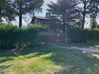 a house with a red fence and a yard at Estacion Potrero cabaña grande in Potrero de Garay