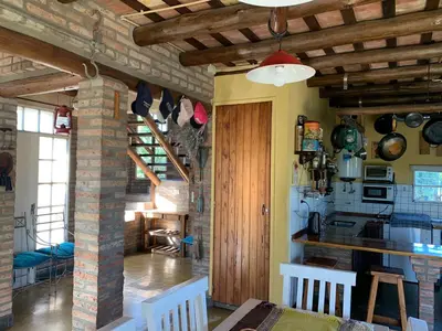 a kitchen and living room with a table and chairs at Estacion Potrero cabaña grande in Potrero de Garay