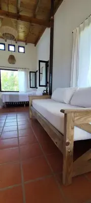 a bedroom with two beds and two windows at Alebrijescalamuchita in Villa Ciudad Parque