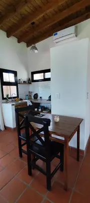 a wooden table and a chair in a room at Alebrijescalamuchita in Villa Ciudad Parque
