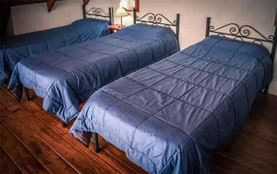 two beds in a bedroom with blue comforters at Cabañas Cerro Cristal in La Cumbrecita